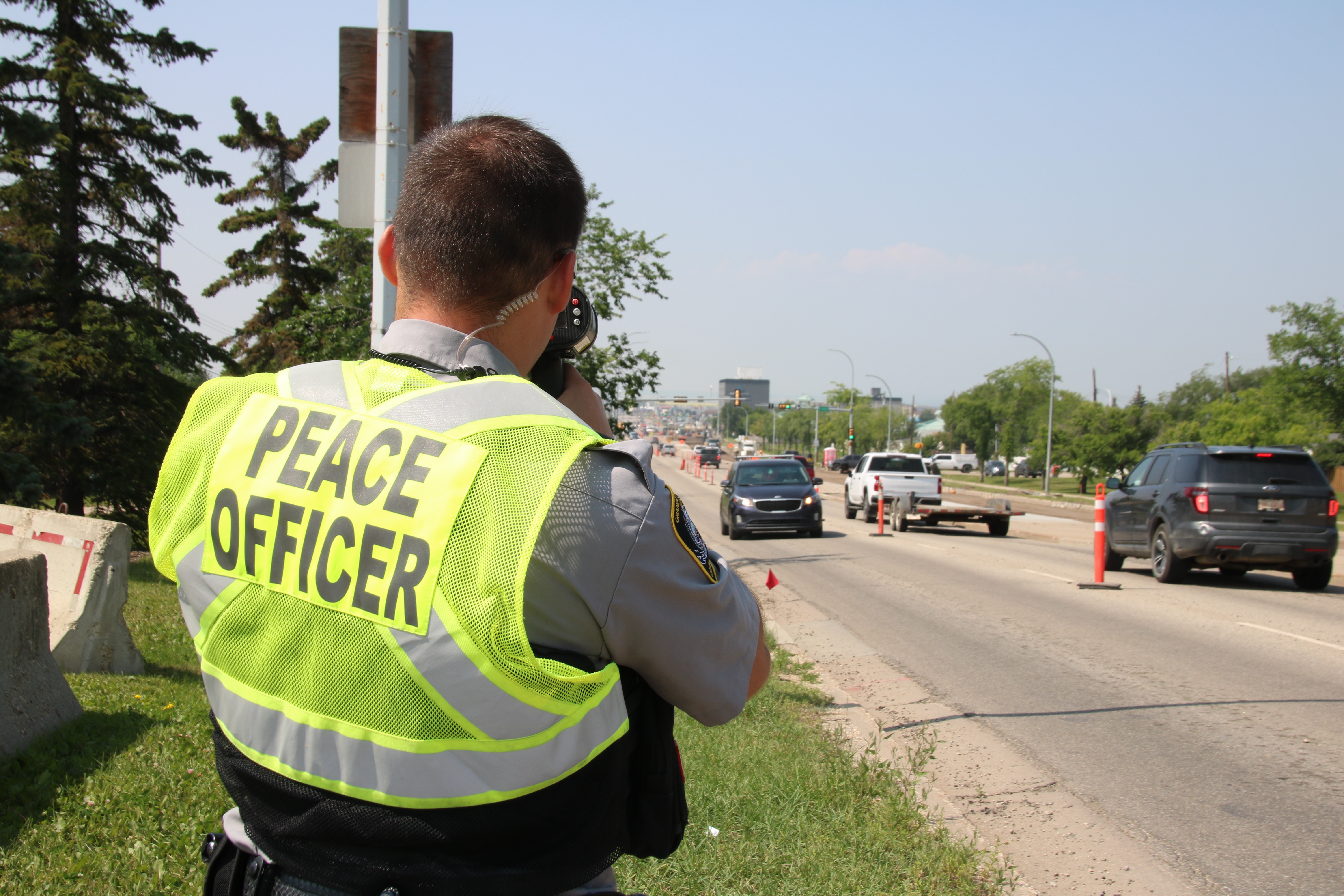 A Peace Officer operates a photo radar gun