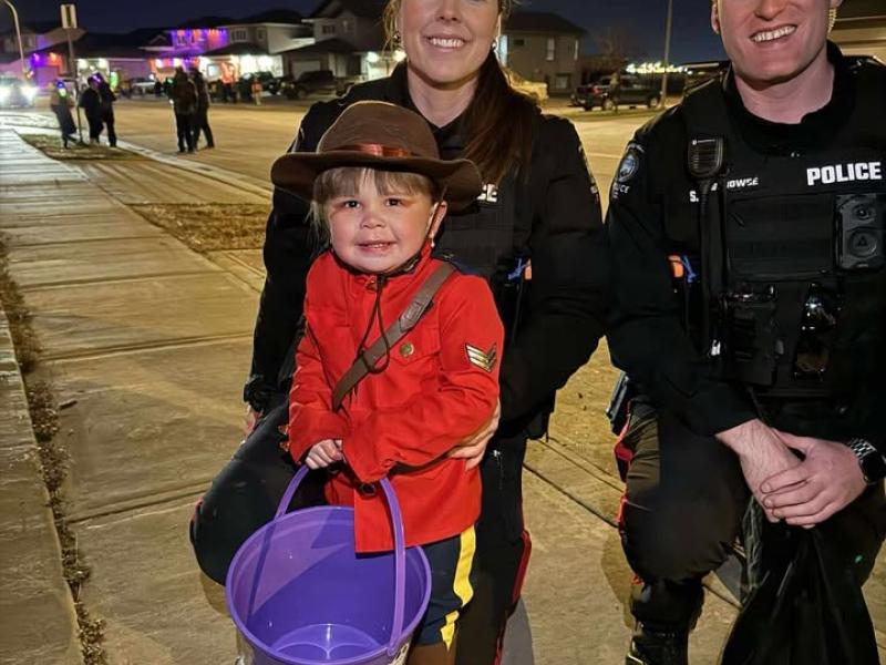 Grande Prairie Police Service members with a trick-or-treater